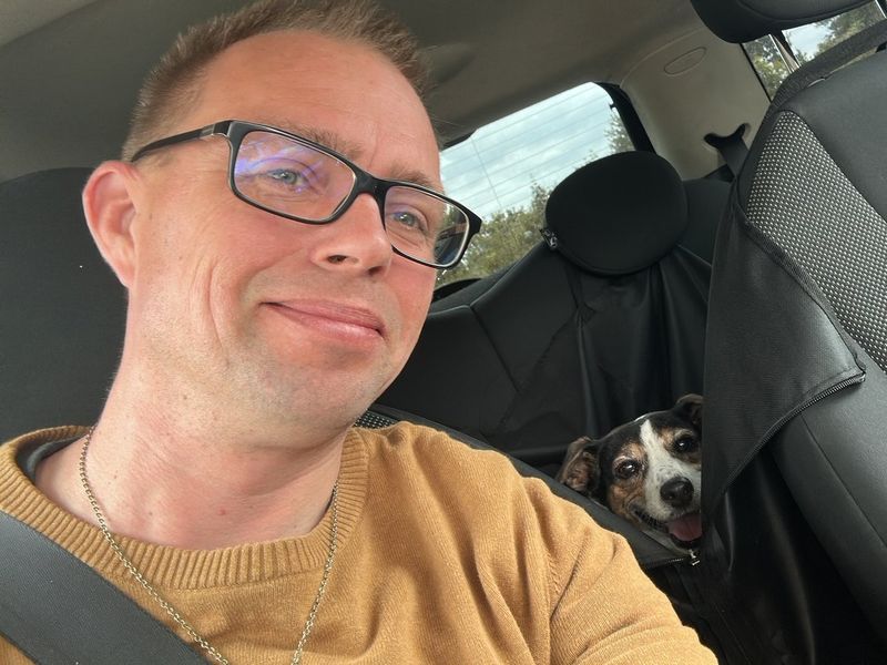 Stepan in the car with his dog Pasha looking over the seat